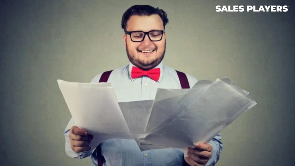 Man smiling and reviewing sales resumes
